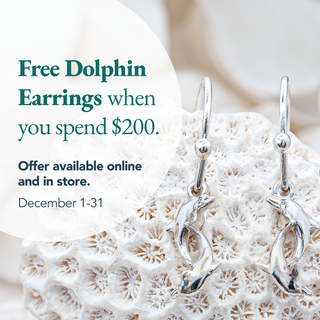 Silver dolphin earrings on coral with promotional text for free earrings with $200 spend.