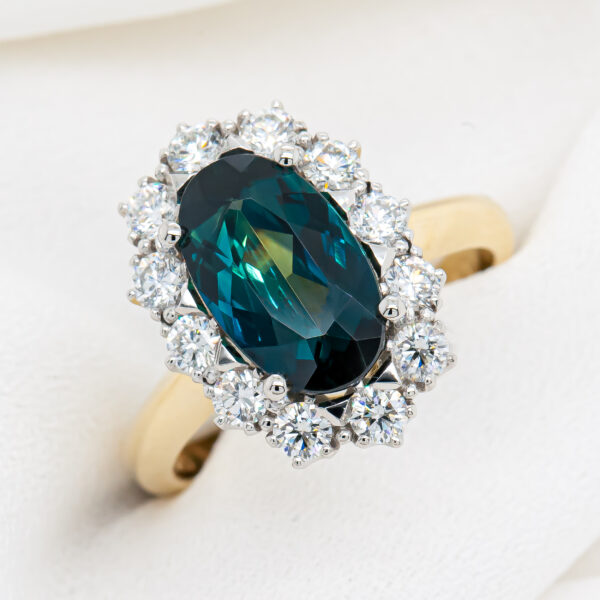 Oval Blue Parti Sapphire Ring with Halo of Diamonds in Platinum and Yellow Gold by World Treasure Designs